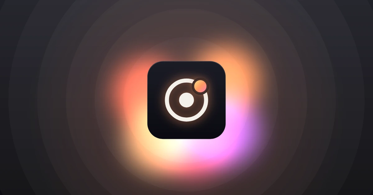 A cream ring around a dot, with a small glowing orange body on the ring, on a dark glass tile with orange and pink light spilling out from behind it.